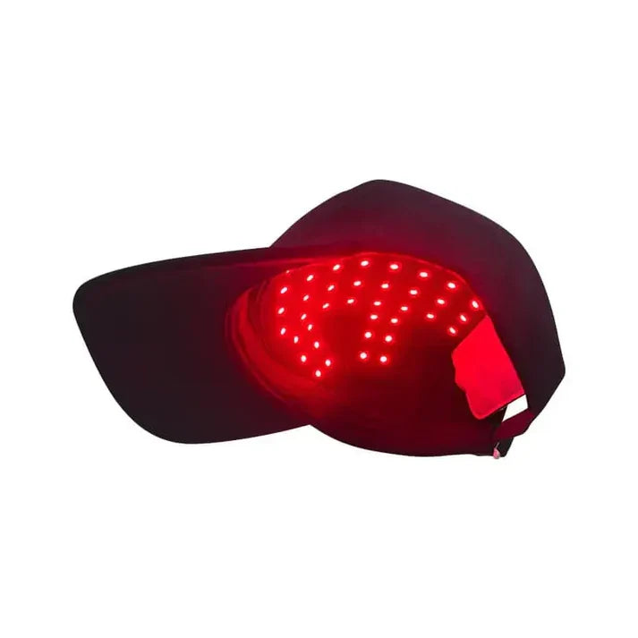 Svart rödljusterapi keps sedd underifrån med röda LED-dioder synliga inuti kepsen, vit bakgrund