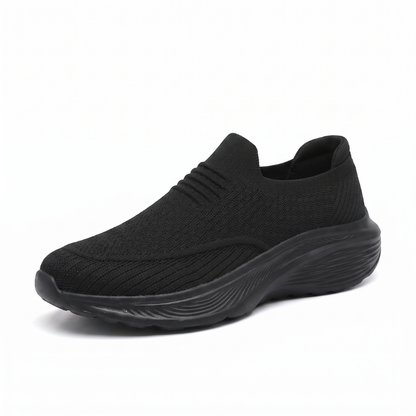 Svart slip-on komfortsko unisex med tjock stötdämpande sula och mjukt sticktyg mot vit bakgrund