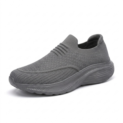 Grå slip-on komfortsko unisex med stötdämpande sula och stretchigt sticktyg mot vit bakgrund