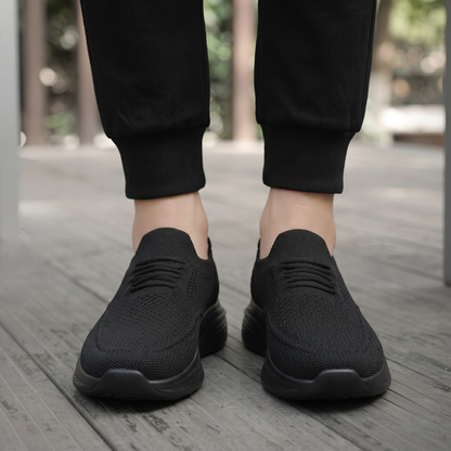 Svarta slip-on komfortskor unisex burna utomhus på trädäck, vy framifrån