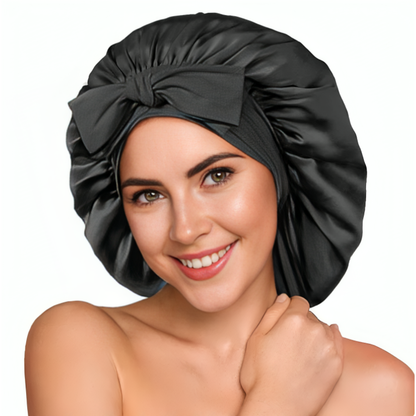 Kvinna ler och bär en svart satin bonnet med rosettdetalj framtill