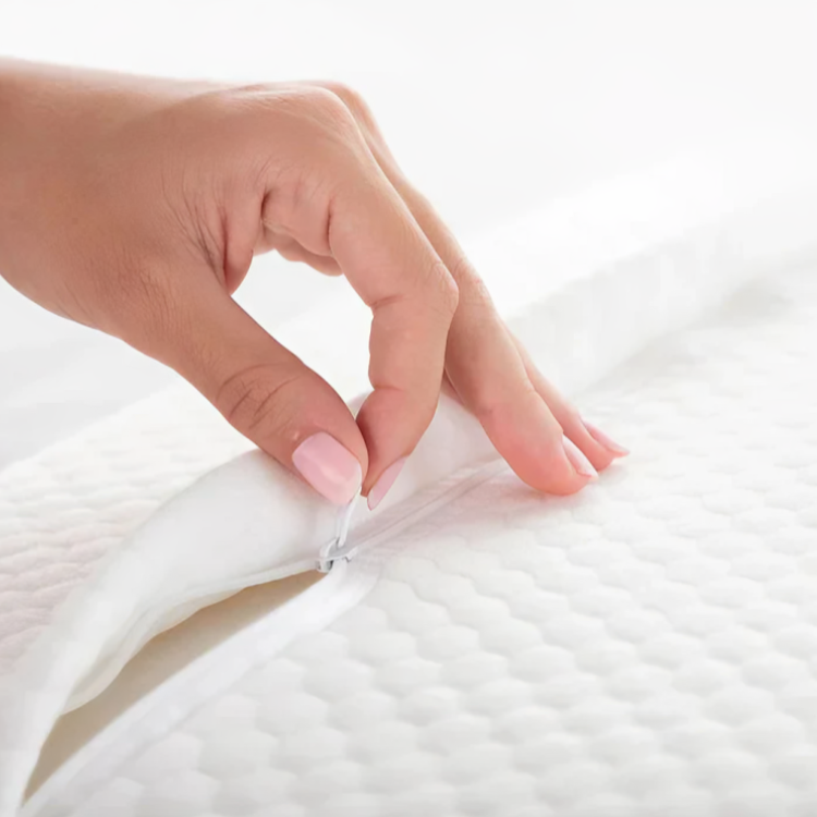 Närbild på hand som öppnar blixtlåset på den avtagbara kuddfodret på ergonomisk kudde