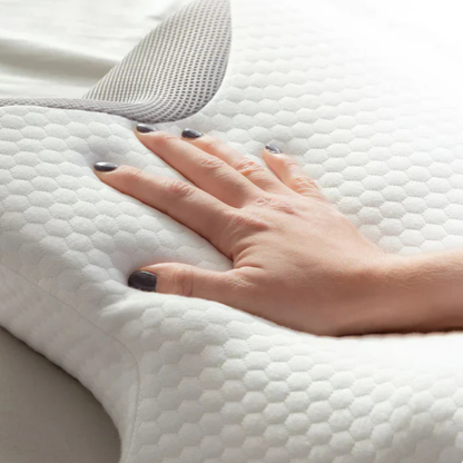 Närbild på hand som trycker på ergonomisk minnesskumskudde med vit honeycomb-täckning
