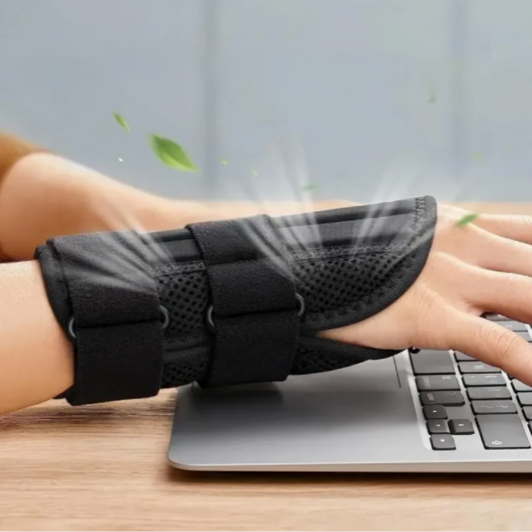 Person skriver på laptop med handledsstöd på vänster hand, ventilationspilar visar andningsbart material
