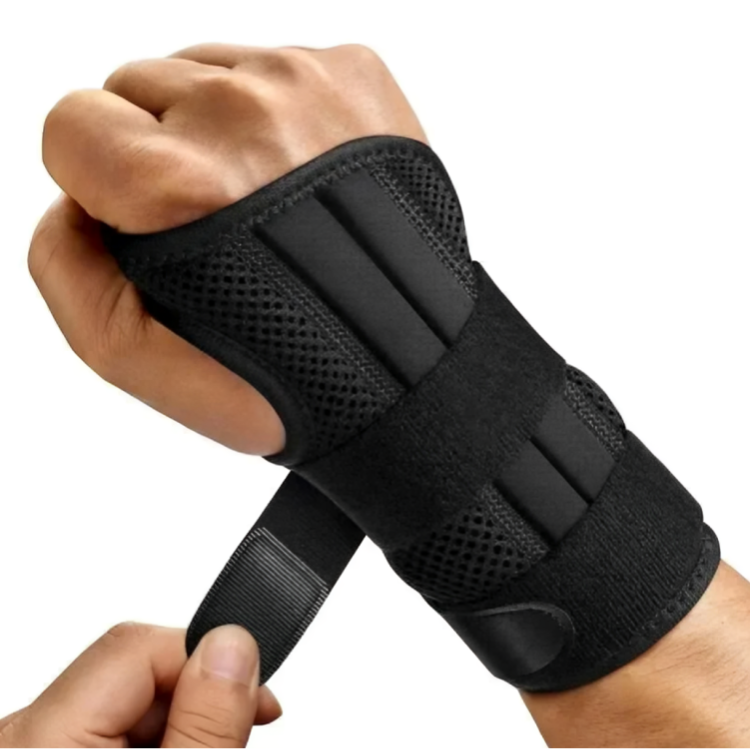 Svart handledsstöd med mesh-material på knuten hand, kardborreband hålls av andra handen vid påtagning