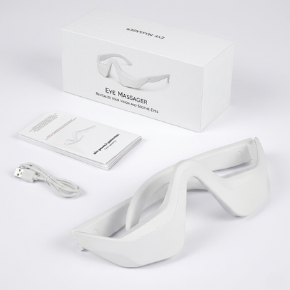 InfraRelief™ Ögonmassager produktpaket – vit enhet, USB-laddningskabel, användarmanual och förpackning mot vit bakgrund