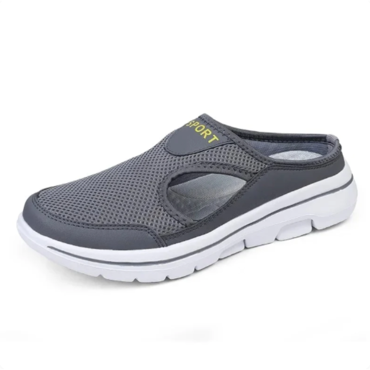 Slip-on sko i grå mesh med svart kant och vit sula, sedd från sidan med öppen häl