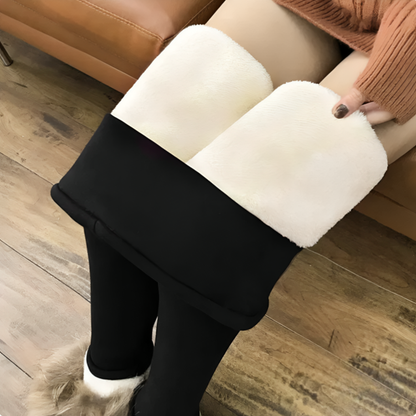 Närbild underifrån på svarta värmeleggings med benen uppvikta som visar det vita fleecefodret